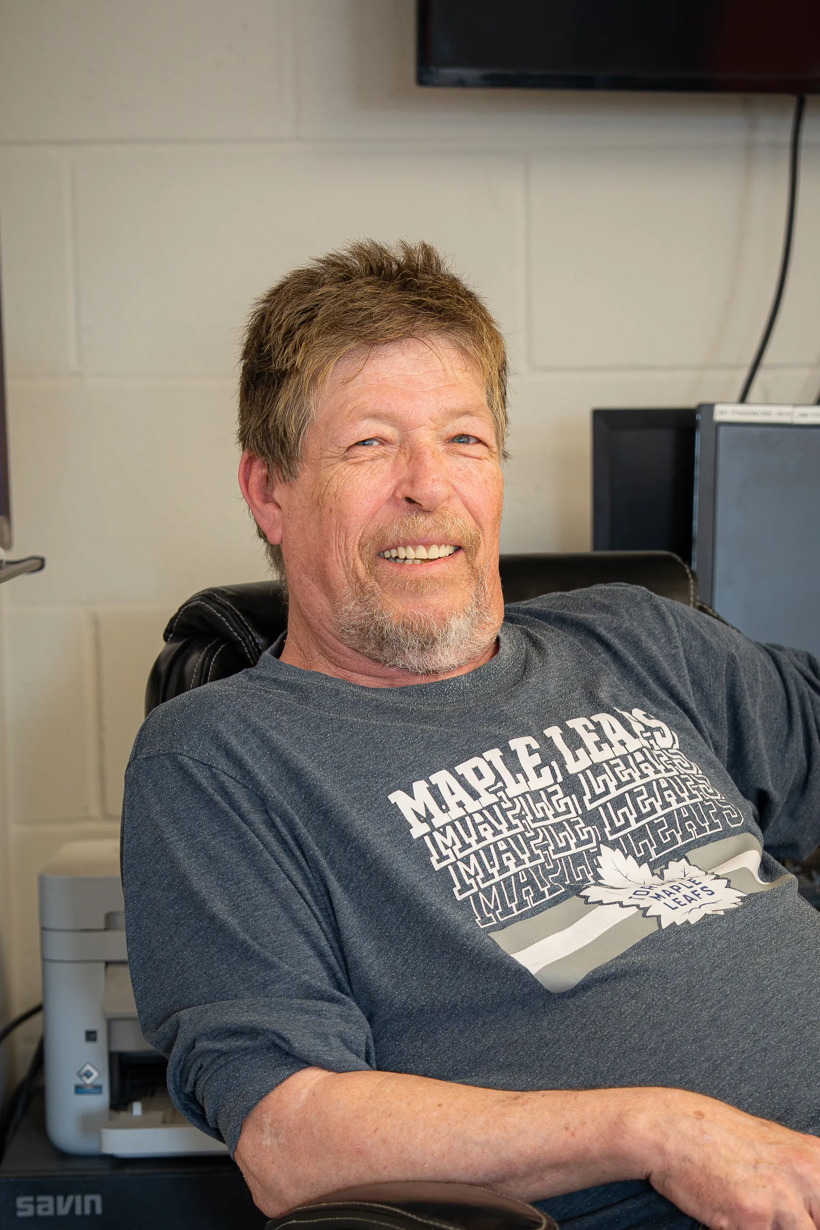 JDA team member smiling in his office chair in a relaxed workspace